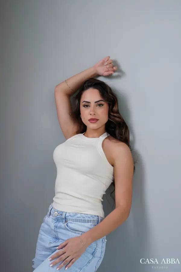 Retrato feminino descontraído com regata branca e jeans